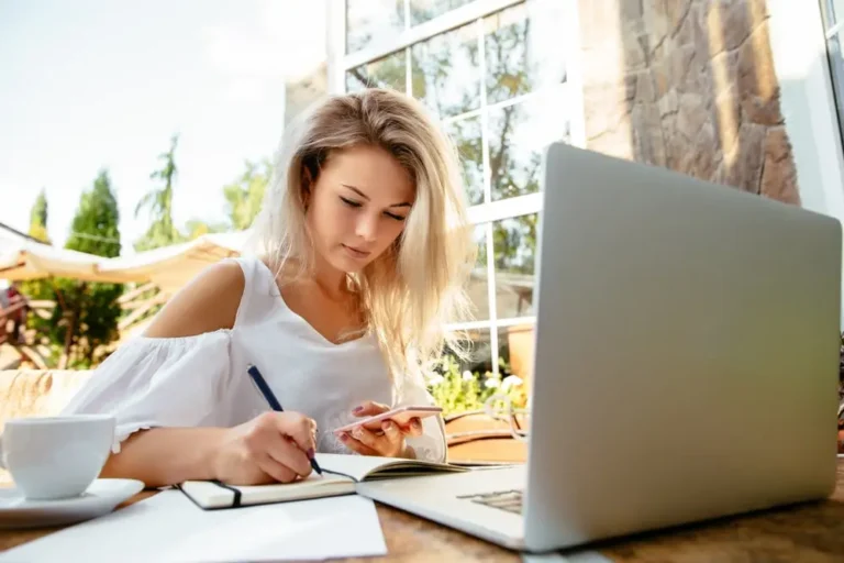 Image représentant un rédacteur de thèse professionnel en train de travailler sur un projet académique, avec un ordinateur portable et des documents sur un bureau.